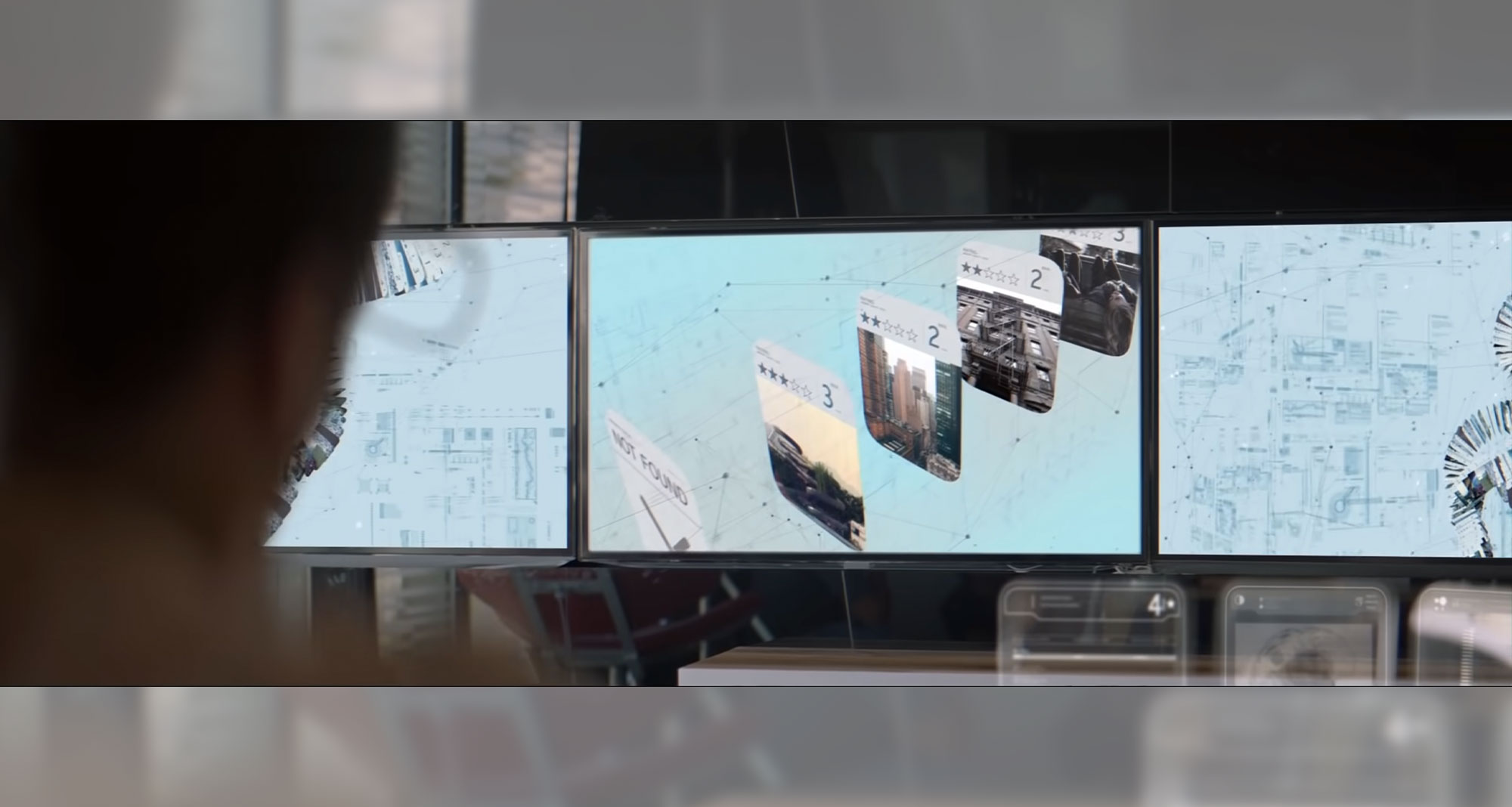 Beyond Money short film screenshot: Person looking at three computer monitors