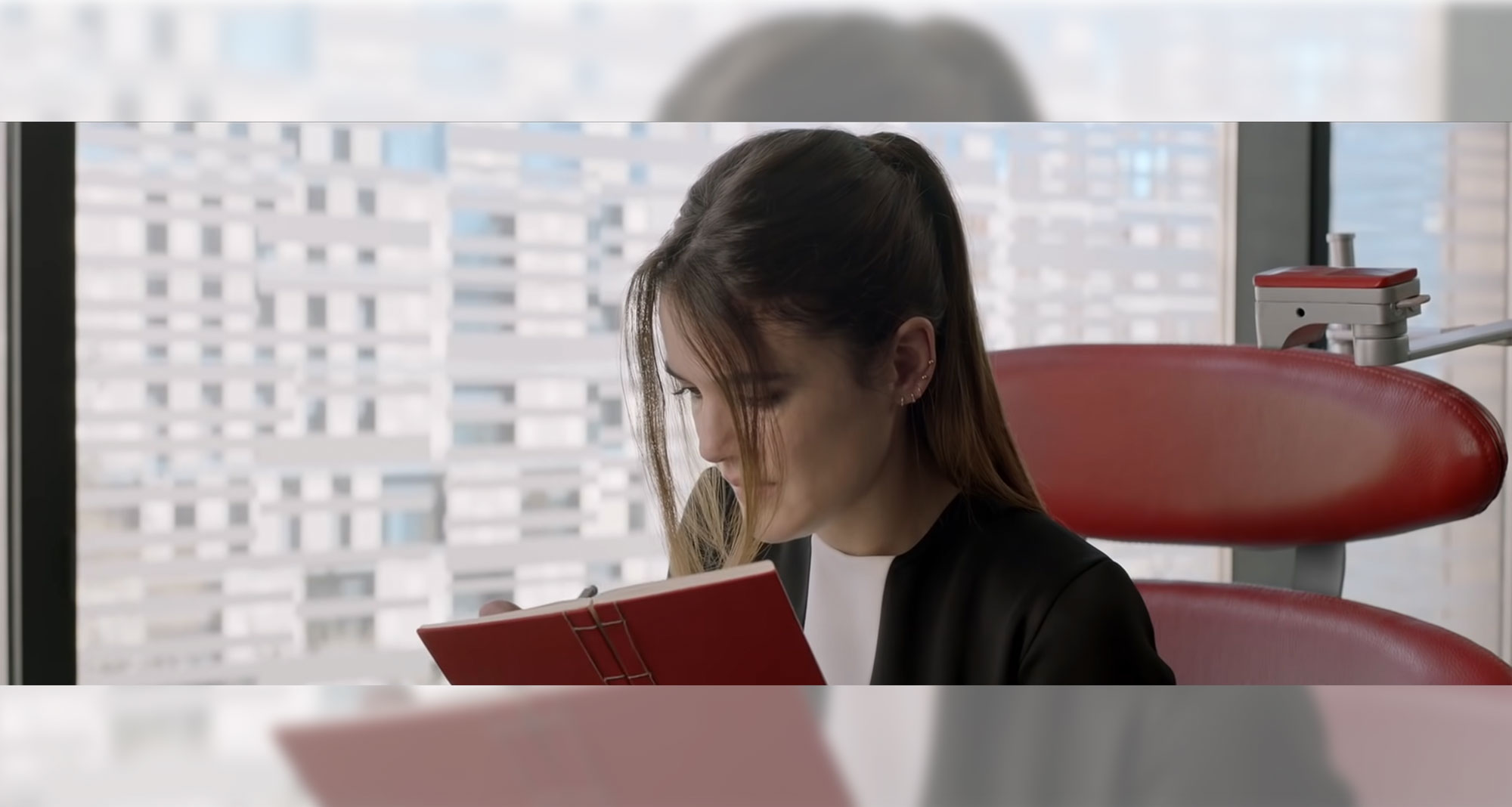 Beyond Money short film screenshot: Woman in chair writing in journal